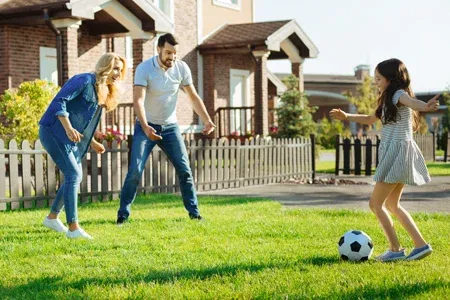 family playing in healthy front yard with green grass