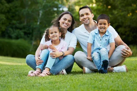 family sitting in backyard on green grass healthy grass