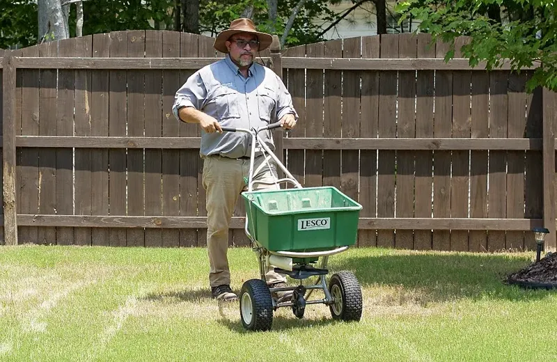 Triangle Lawn Care technician fertilizing lawn