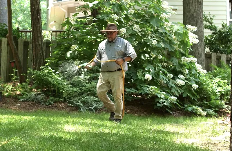 technician spraying lawn, pest prevention